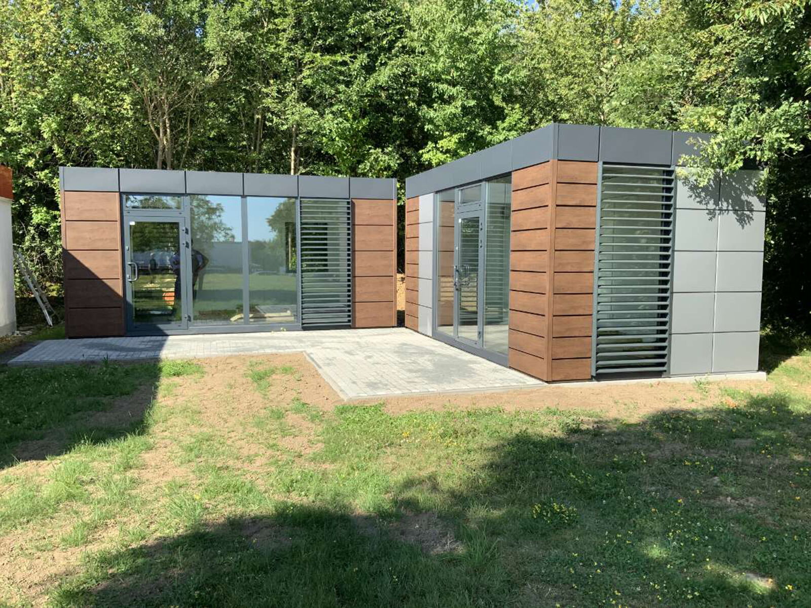 Twee moderne modulcontainers met hout- en metalen gevel in het groen      