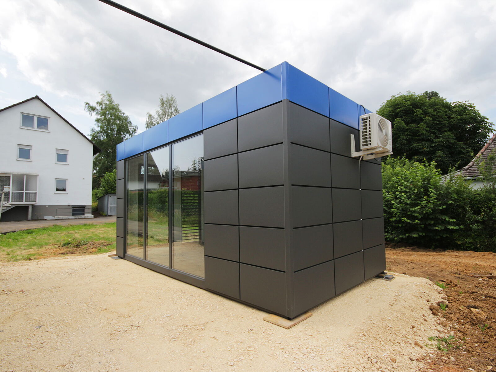 Compacte kantoorcontainer met glasvoorkant en airco in de buitenruimte      